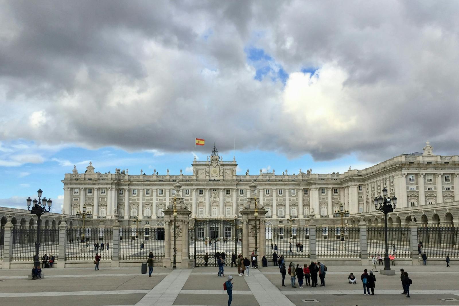 Frontalutsyn over Det spanske kongepalasset i Madrid under skyet himmel